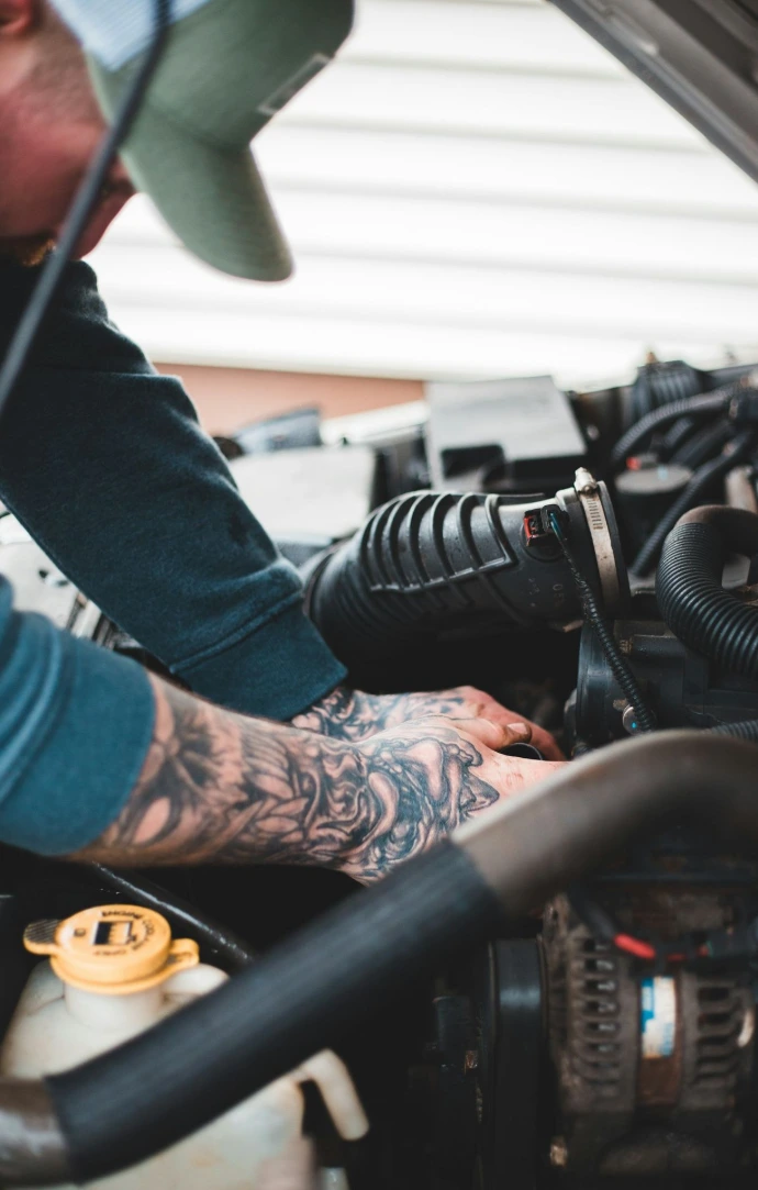 person in blue denim jeans and black and white adidas sneakers riding on black motorcycle